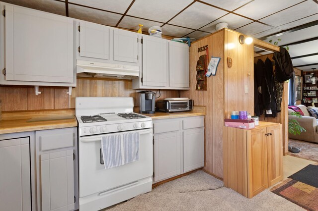 kitchen with under cabinet range hood, white gas stove, a toaster, and light countertops