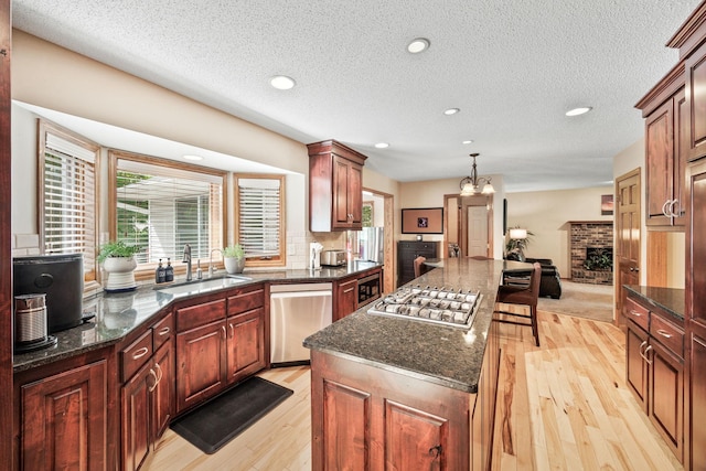 4545 Terraceview Ln N, Plymouth, MN 55446 - kitchen with a sink, appliances with stainless steel finishes, a center island, light wood finished floors, and a textured ceiling