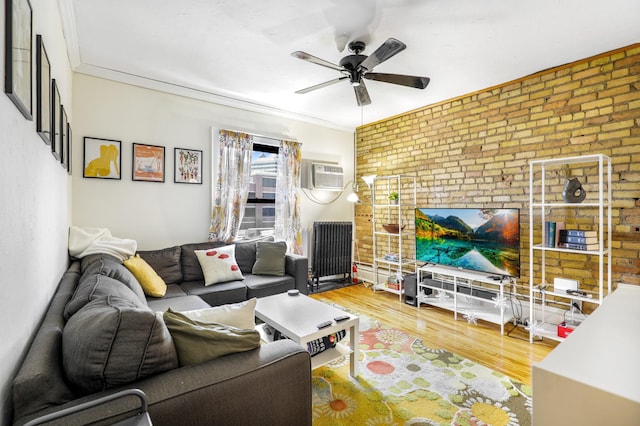 living room with wood finished floors, a ceiling fan, brick wall, an AC wall unit, and crown molding