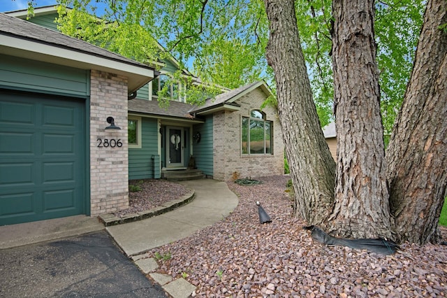 2806 Jasmine Ct, Saint Cloud, MN 56301 - entrance to property featuring brick siding, a shingled roof, and a garage