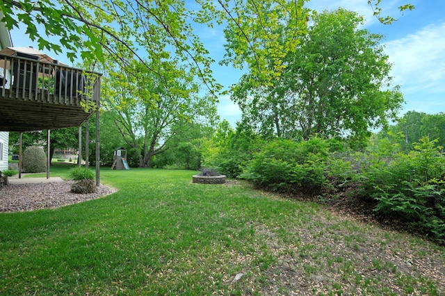2806 Jasmine Ct, Saint Cloud, MN 56301 - view of green lawn with a fire pit, a playground, and a wooden deck
