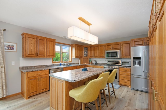 2806 Jasmine Ct, Saint Cloud, MN 56301 - kitchen with stainless steel appliances, a sink, light wood-style floors, and brown cabinets