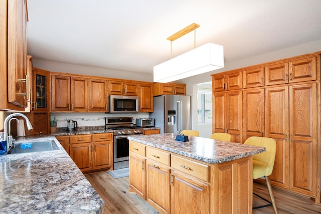 2806 Jasmine Ct, Saint Cloud, MN 56301 - kitchen featuring stainless steel appliances, a sink, light wood-type flooring, a kitchen breakfast bar, and a center island
