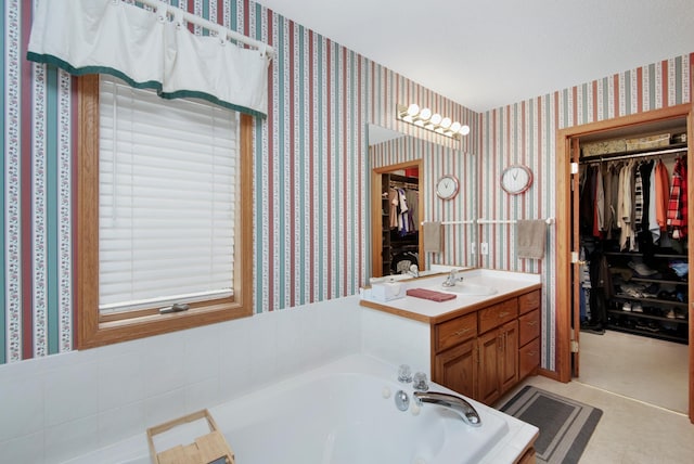 2806 Jasmine Ct, Saint Cloud, MN 56301 - bathroom with wallpapered walls, a spacious closet, a garden tub, and vanity