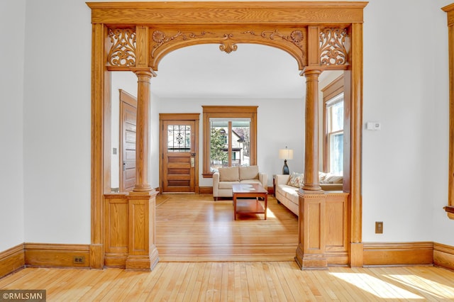 entrance foyer featuring decorative columns and light wood-type flooring