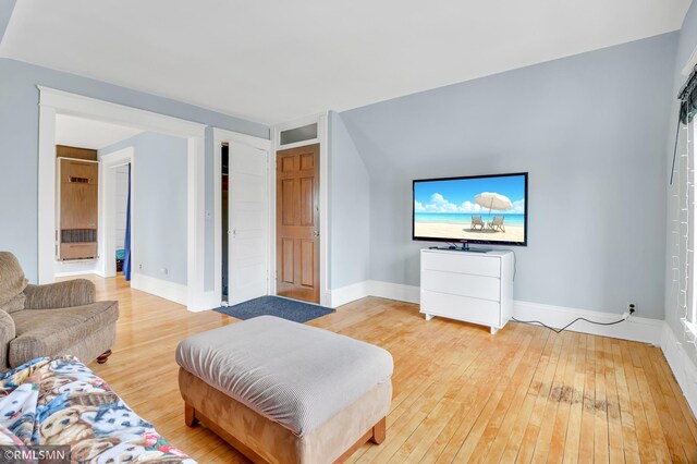 living area featuring wood-type flooring and baseboards