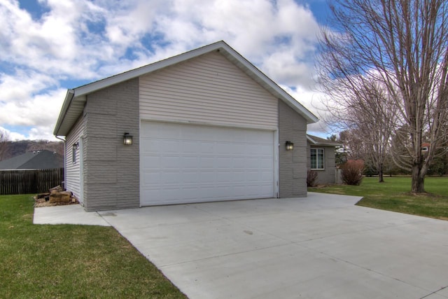 view of side of home with fence, concrete driveway, a yard, and a garage