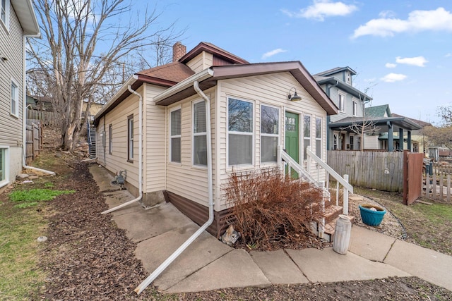 2943 Taylor St NE, Minneapolis, MN 55418 - view of front facade featuring fence, a chimney, and entry steps