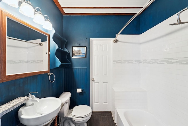 2943 Taylor St NE, Minneapolis, MN 55418 - bathroom featuring wood finished floors, a sink, a wainscoted wall, toilet, and washtub / shower combination