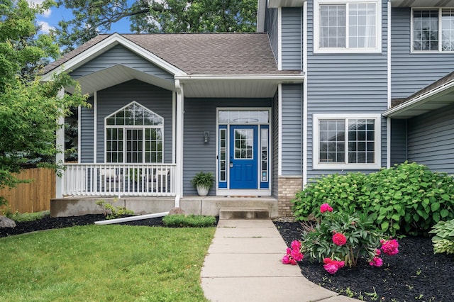 4032 Hollyhock Cir N, Brooklyn Park, MN 55443 - doorway to property featuring a shingled roof and covered porch