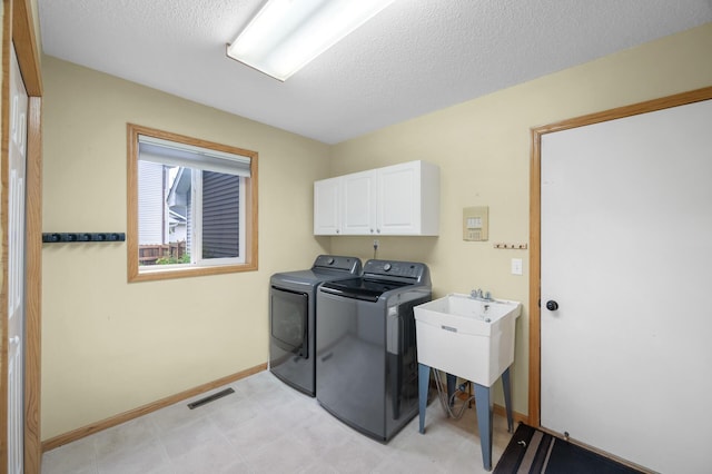 4032 Hollyhock Cir N, Brooklyn Park, MN 55443 - washroom with cabinet space, washing machine and dryer, a textured ceiling, and light flooring