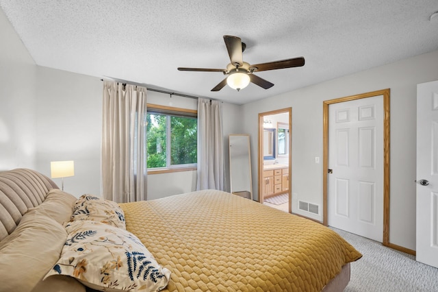 4032 Hollyhock Cir N, Brooklyn Park, MN 55443 - bedroom with light carpet, a textured ceiling, a ceiling fan, and connected bathroom