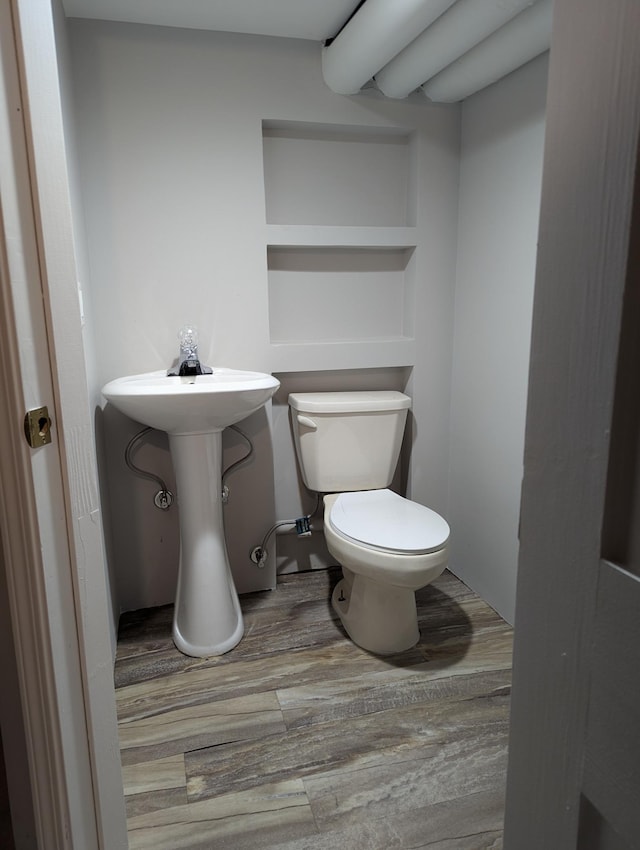 bathroom with toilet and wood finished floors