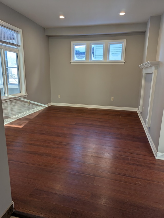 empty room with plenty of natural light, recessed lighting, baseboards, and dark wood-style floors