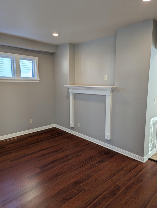 basement featuring baseboards, recessed lighting, dark wood-style floors, and visible vents