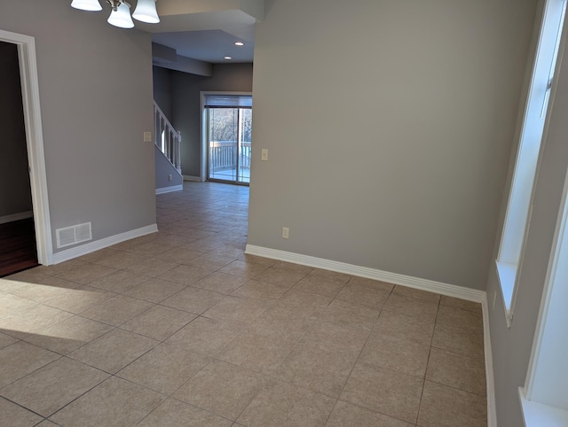 empty room with an inviting chandelier, baseboards, light tile patterned floors, visible vents, and stairway