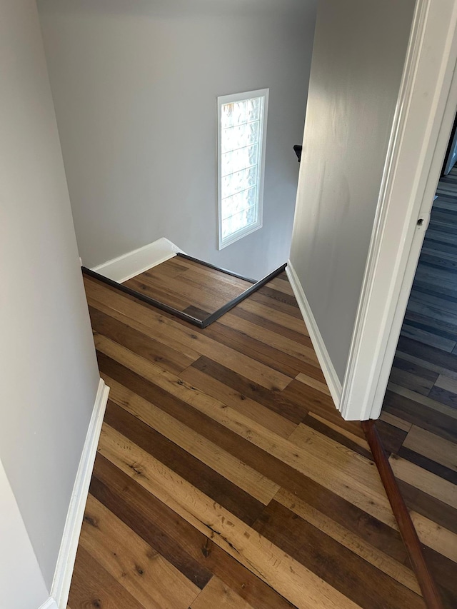 interior space featuring baseboards and dark wood-style flooring