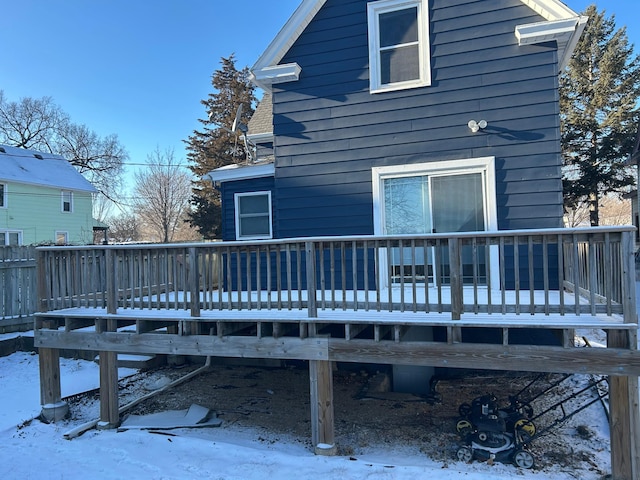snow covered house featuring a wooden deck