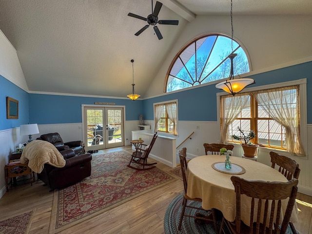 17783 Lookout Tower Rd NE, Hines, MN 56647 - dining area with a wainscoted wall, wood finished floors, ceiling fan, a textured ceiling, and french doors