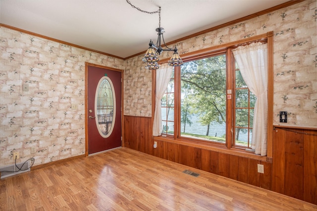 1122 Andrew Dr NE, Lake Andrew Twp, MN 56273 - foyer with crown molding, wood finished floors, wainscoting, a chandelier, and wood walls