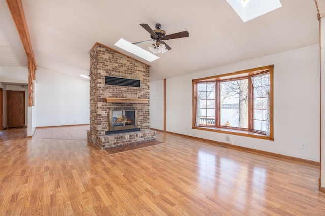 1122 Andrew Dr NE, Lake Andrew Twp, MN 56273 - unfurnished living room featuring a skylight, a fireplace, baseboards, and wood finished floors