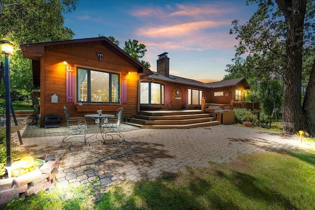 1122 Andrew Dr NE, Lake Andrew Twp, MN 56273 - rear view of house with a chimney, a patio, and a wooden deck