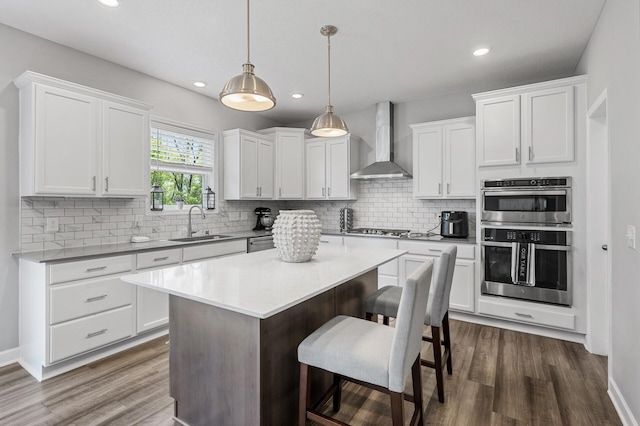 6674 Annabelle Ct, Corcoran, MN 55340 - kitchen with wall chimney exhaust hood, stainless steel appliances, a sink, dark wood-style floors, and decorative backsplash