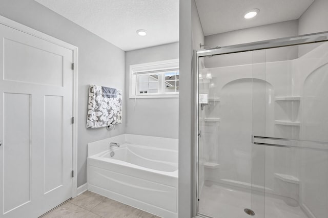 6674 Annabelle Ct, Corcoran, MN 55340 - bathroom featuring a garden tub, a shower stall, tile patterned flooring, a textured ceiling, and baseboards