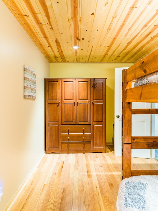 bedroom featuring wooden ceiling, baseboards, and light wood-style flooring