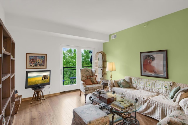 living area with baseboards, wood finished floors, and visible vents