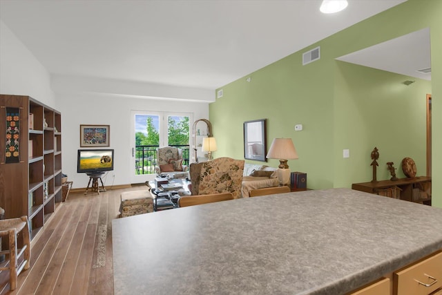kitchen featuring open floor plan, hardwood / wood-style flooring, and visible vents