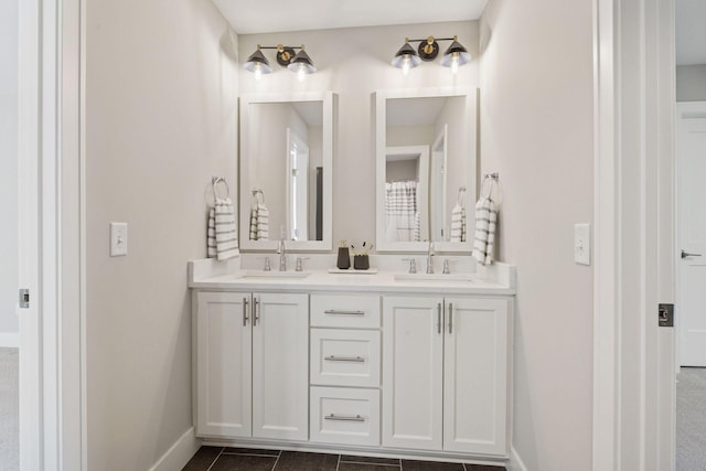 full bathroom with baseboards, double vanity, and tile patterned flooring