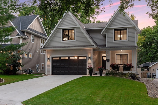 view of front facade featuring a garage, a front lawn, driveway, and covered porch