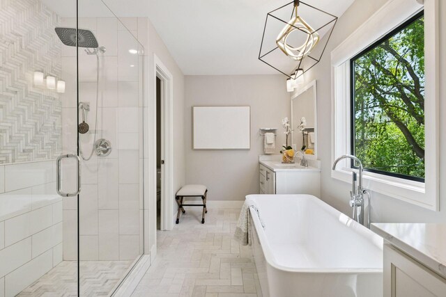 bathroom with a stall shower, a freestanding tub, vanity, and baseboards