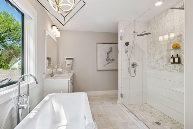 full bath with a freestanding bath, a shower stall, a chandelier, and vanity