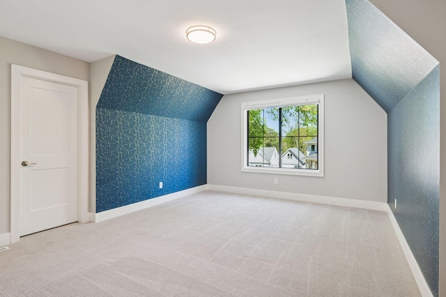 additional living space featuring carpet flooring, baseboards, vaulted ceiling, and wallpapered walls