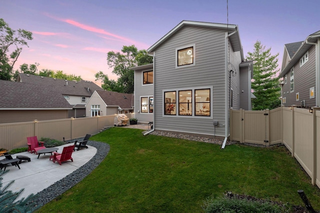 back of house at dusk with a patio area and a gate