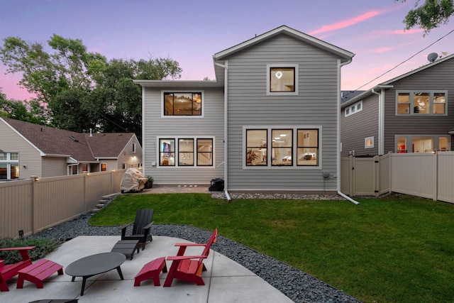 back of house at dusk with a patio area and a gate