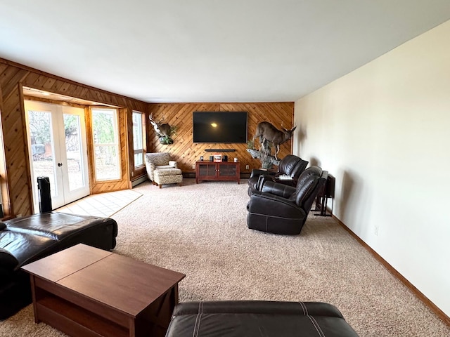 living room with carpet, wood walls, french doors, baseboards, and a baseboard radiator
