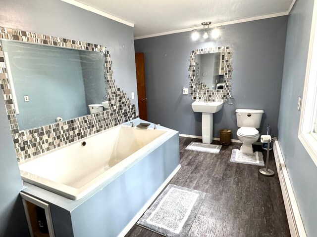 full bathroom with wood finished floors, toilet, ornamental molding, a sink, and baseboards