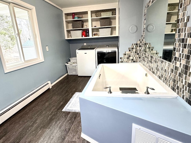 bathroom featuring washing machine and dryer, wood finished floors, baseboards, and baseboard heating