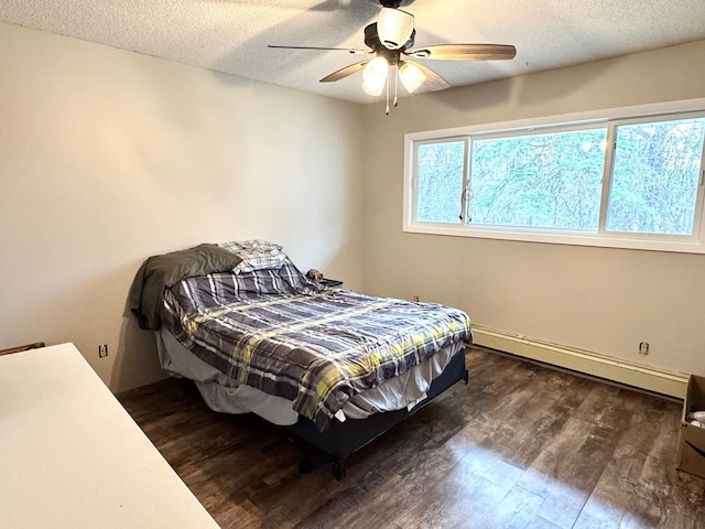 bedroom with a baseboard heating unit, dark wood finished floors, a textured ceiling, and a ceiling fan