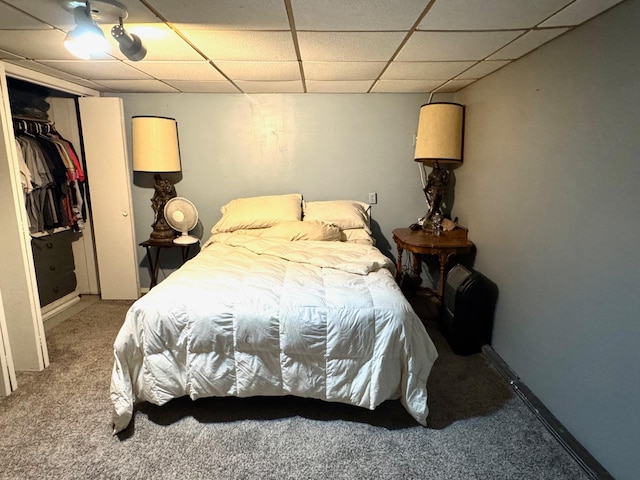 bedroom featuring carpet, a closet, and a drop ceiling