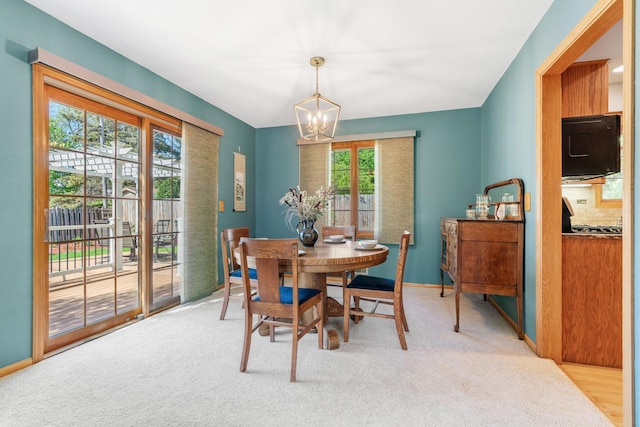 dining area with a chandelier and carpet