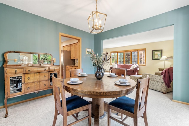 dining room with light carpet and a chandelier