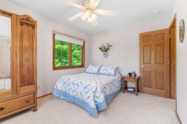 bedroom with light carpet, a ceiling fan, and baseboards
