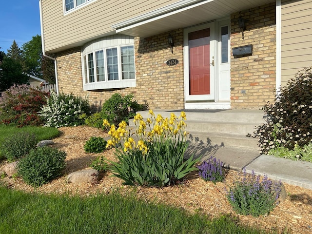 doorway to property featuring brick siding