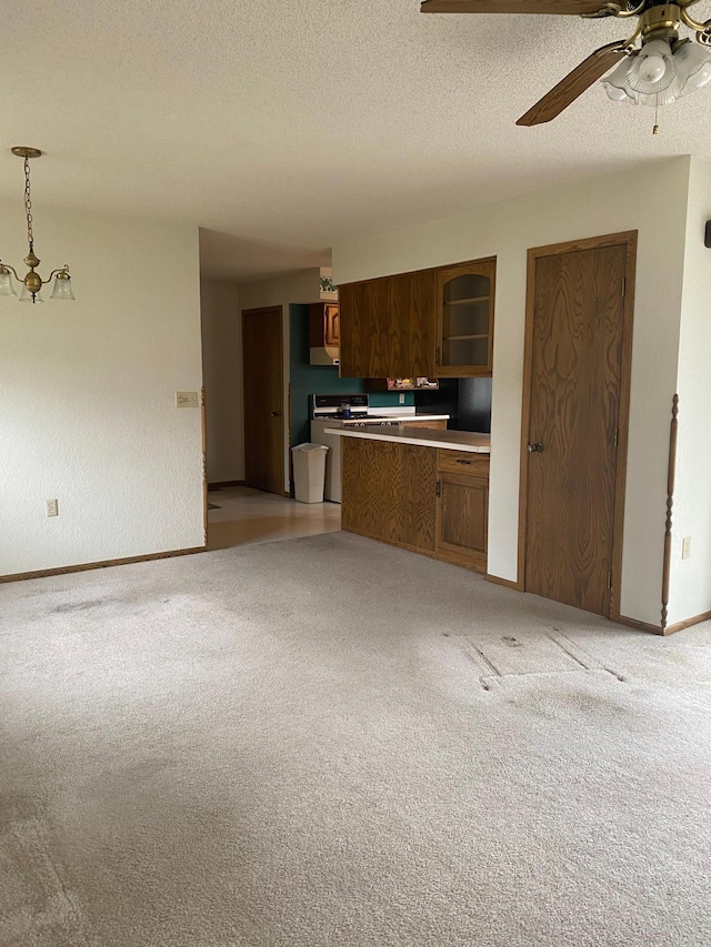 2509 6th St SW, Willmar, MN 56201 - kitchen featuring a textured ceiling, baseboards, light colored carpet, ceiling fan, and brown cabinetry