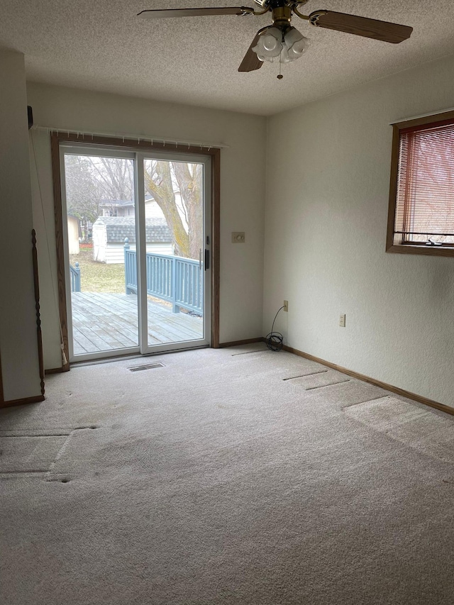 2509 6th St SW, Willmar, MN 56201 - unfurnished room with a textured ceiling, ceiling fan, a textured wall, carpet flooring, and visible vents