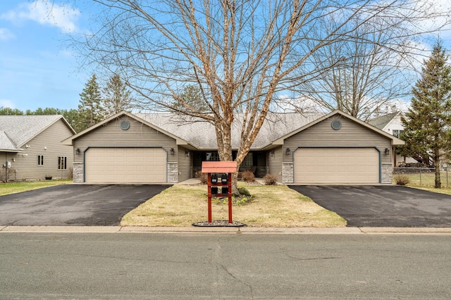 553 Cedar Ct, Taylors Falls, MN 55084 - view of front of property featuring an attached garage, driveway, and stone siding